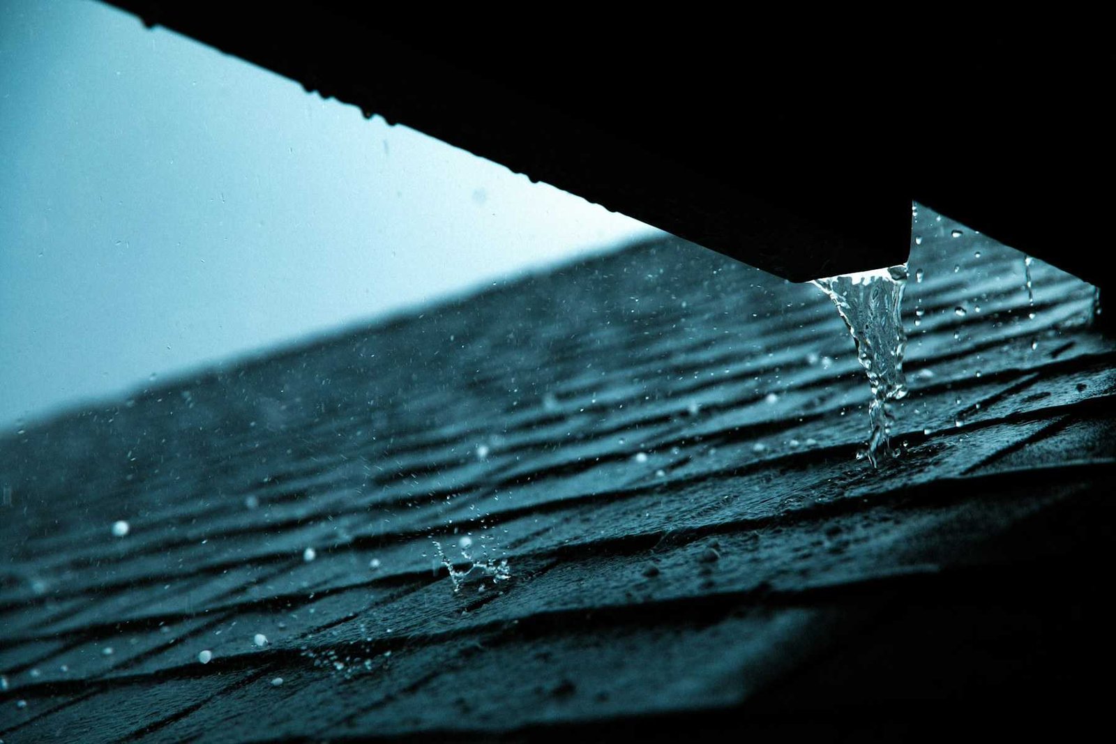 Eau de pluie qui ruisselle au bord d’une toiture